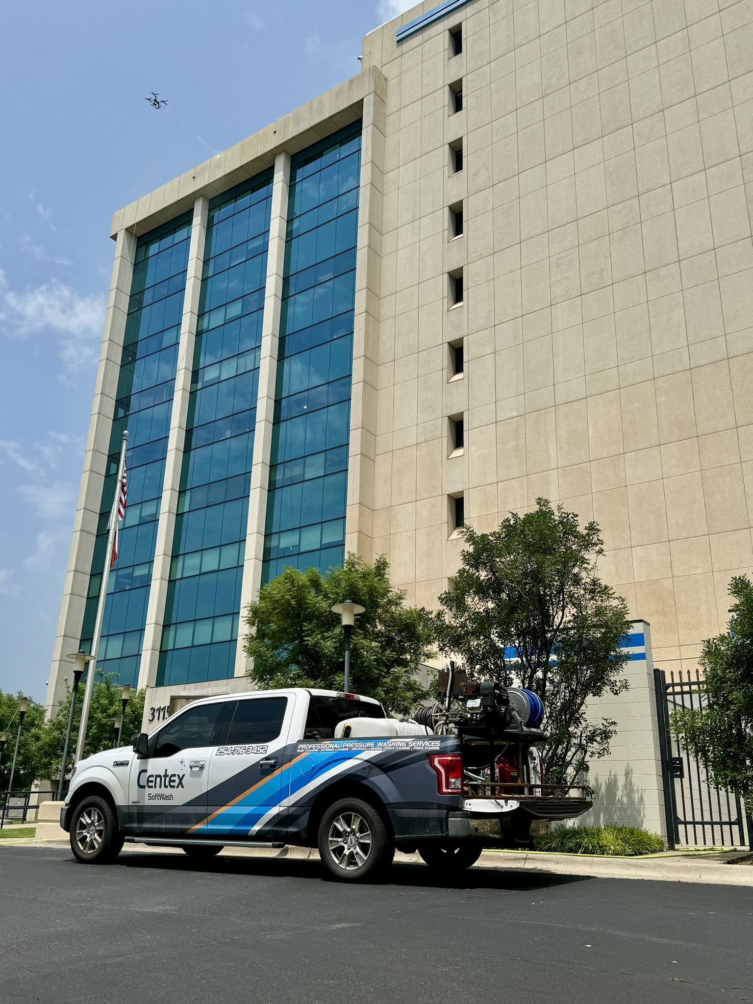 Centex Softwash professional truck and equipment in front of modern commercial office building in Central Texas